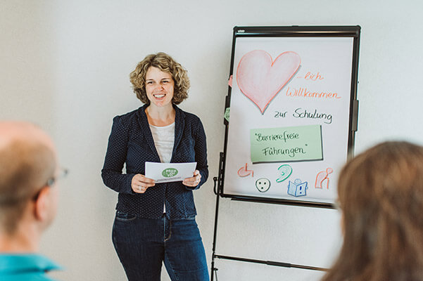 Gisela Moser an einem FlipChart vor Schulungsteilnehmern