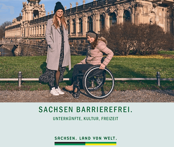 Ausschnitt vom Cover der Broschüre "Sachsen barrierefrei". Foto von zwei jungen Damen, davon eine im Rollstuhl vor einem historischen Gebäude