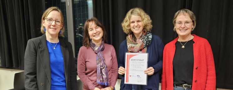 Gisela Moser mit einem Zertifikat in der Hand, außerdem drei offiziell aussehende Damen
